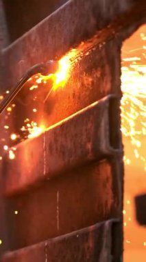 Metal bir levhayı gaz kaynaklama makinesiyle kesen yetenekli bir adam. İtfaiye aracındaki büyük kıvılcımların yavaş çekim görüntüleri. Eldivenli yetenekli bir adam çelik levha kaynaklarını kontrol eder..