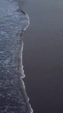 Tropik sahil adası ve okyanusun havadan görünüşü, turkuaz suyla güneşin doğuşunun drone görüntüleri, 4k UHD. Dikey çekim.