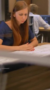 Modern ofis üç personel masada çizim kağıt bakın ve konuşuyor. İki güzel genç kadın ve erkek bir masanın arkasında oturan ve atış yavaş hareket ortada tartışmak. 4 k Ultra Hd