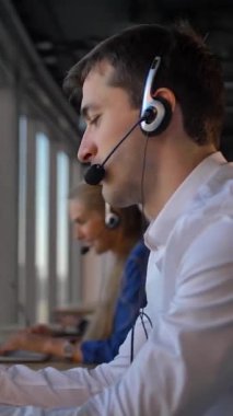 Yakışıklı işadamı girişimci kulaklık iş ofis çağrı merkezi cuctomers için aradım. Arkadaşları da arama ve müşterileri ile telefonla iletilecektir. Yavaş hareket 4k kaymak kamera