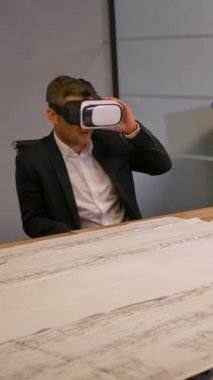 Çalışan ve iş arkadaşları VR Gelecek Teknoloji ve çizim üzerine çalışıyorlar. Modern cam ofiste inşaatın mühendislik çözümlerini tartışırız. 4k Yavaş çekim dikey çekim.