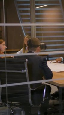 İş ekibi, Kafkasyalı ve Aframerikalı sanal gerçeklik gözlükleri kullanarak yol çizmeyi tartışıyorlar. Cam duvarlı modern ofis. 4k UHD yavaş çekim. Dikey çekim.