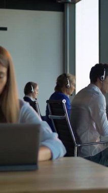 İş yerindeki çağrı merkezini patron kadın kontrol ediyor. Kendine güvenen ve zeki bir yöneticiye benziyor. Kameraya bakarken gülümsüyor. Modern binanın içinde, iş alanı penceresi manzaralı. Dikey