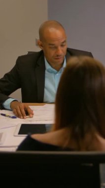 Sanal gerçeklik gözlüklü kendine güvenen girişimci. Bir grup genç mühendis çalışıyor. Çeşitli iş adamları toplantı odasını arıyor. 4k UltraHD dikey çekim.