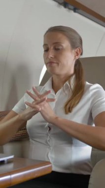 İş kadını özel jet sörfünde dizüstü bilgisayar kullanıyor. Elini uzatıyor ve internette yazmaya ya da sörf yapmaya başlıyor. Dikey çekim.