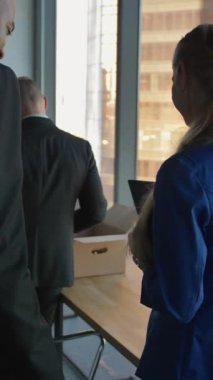 Afro-Amerikalı iş adamı meslektaşlarına ve çalışanlarına yardım ediyor. Modern ofis 4K 'de takım çalışması. Dikey çekim.