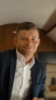 Lüks jetin içinde dans eden mutlu iş adamı. Girişimci rahat birinci sınıf uçuştan memnun. Ağır çekimde yakın çekim. Dikey çekim.