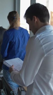 Siyah deri Afro-Amerikan patron onun meslektaşları ile kutuları ve belgeleri ve büyük pencereler ve işletme bölge görünümü ile modern ofis elektronik teşvik eder. 4 k Ultrahd pürüzsüz kamera hareketi