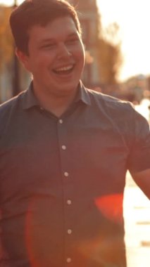 Aktif arkadaşlar beşlik çakar, erkek ve kadın, güzel bir haber ve mutlu sonla biten günün anısına, arkasında altın güneş parıldar. Süper yavaş çekim, gün doğumu ya da gün batımı. Dikey çekim.