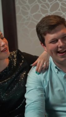 Şirket pokeri. Erkek ve kız arkadaşı poker oyunu kazanıyor. Gülümsüyor, kaybedenlere göz kırpıyor. Viski ve kola içiyorum. 4k Ultra Hd ağır çekim. Dikey çekim.