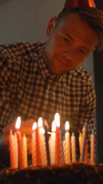 Seksi bayan ve yakışıklı adam lezzetli doğum günü pastasına mum yakıyor. Partiye hazırlanıyorum. Erkekler yüz yüze. Handy 4k Ultra HD yavaş çekim. Dikey çekim.