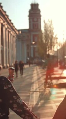 Mutlu çiftin şehir merkezinde buluşup dondurma yemesi. Gün batımında güzel ilişkiler gülümser ve mutlu olur. Süper yavaş çekim orta arka görünüm. Dikey çekim.