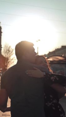 Çekici erkek ve genç bayan şehirde eğleniyor. Duygusal olarak dans ediyorlar, gülüyorlar ve gülüyorlar. Sun lightleak. Orta görüş. Zaman gerçek ve yavaş karışımı. Gün doğumu ya da günbatımı. Dikey çekim