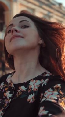 Selfie 'nin komik, çekici, çilli ve yakışıklı kız görüntüsü. Güneşli bir akşam. Işıklılar. Gülümsemekten ve gülmekten mutlu, kızıl saçlarını taramaktan. Geniş mercek. Yüze yakın çekim. Dikey çekim.