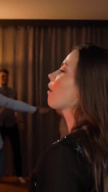 Seksi kızıl, çekici kadın partide neşeyle dans ediyor. Tipik düz doğum günü kutlaması. BG 'de arkadaşlar dans eder. Ağır çekim. Dikey çekim.