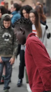 BOLOGNA, İtalya - 27 Mayıs 2018: Afro-Amerikalı çocuk sanatçının dikey çekimine bakıyor.