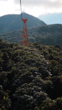 Dominik Cumhuriyeti, Bavaro 'da asfalt yoldan geçen arabanın görüntüsü. Dağların güzel manzarası, mavi gökyüzü, bulutlar, deniz mavisi ve turuncu şekilli. Kullanışlı dikey çekim.