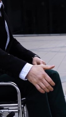 Mutlu patron tekerlekli sandalyedeki engelli çalışanın elini yavaş çekimde sıkıyor. Gün batımı ya da gün doğumu. Mutluluk. Servet ve konforlu çalışma ve ortaklık dikey çekim.