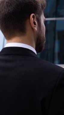 Başını kapatarak ve şüphe yavaş hareket ile kamera açık arıyor işadamı portresi geri. Cam iş merkezi yürüyebiliyor. Ağır çekim. Güneşli yumuşak hafif atış akşam. 240 fps