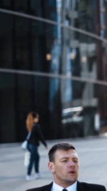 Tekerlekli sandalyedeki kötürüm patron girişimcisi, genç ve çekici iş kadınına dijital yastıklı bir iş kadını olduğunu gösteriyor. Güneşli açık hava çekimi, gün doğumu. Dikey çekim.