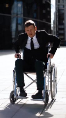 Tekerlekli sandalyeden kalkmaya çalışan sakat iş adamı. O, AIDS 'siz olduğu için gergin ve hayal kırıklığına uğradı. Geniş açı. Kimse ona yardım etmesin. Dikey çekim.