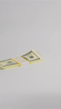 Süper yavaş çekim. Beyaz yüzeye çok az dolar düşüyor. Zıpla ve kaç. Büyük para konsepti Dikey Atış.