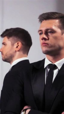 Üç yakışıklı iş adamının, iş adamlarının ve iş kadınlarının içerideki görüntüsü başlarını kameraya çeviriyor. süper yavaş çekim dikey çekim.