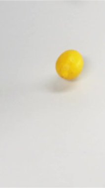 Taze sarı limonlar düşüp zıplıyorlar. Ağır çekim modunda yüksek hızlı kamera ile çekim. Limonlar kamerada çok hızlı hareket eder. Beyaz siklonama bg izole edilmiş dikey çekim.