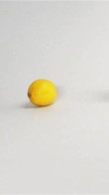 Taze sarı limonların birkaçı beyaz zemine düşüp zıplıyorlar. Ağır çekim modunda yüksek hızlı kamerayla çekildi. Limonlar kameraya doğru çok hızlı hareket eder. Beyaz siklonama arkaplanı izole edilmiş dikey
