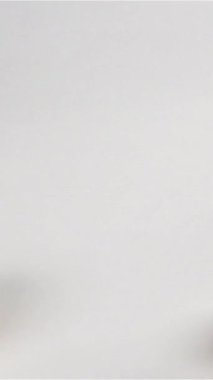 Beyaz masa yüzeyinde kameradan düşen ve ağır çekimde zıplayan birkaç beyaz mantar şampiyonu var. Macro vuruldu. 500 fps, Dikey Vuruş.