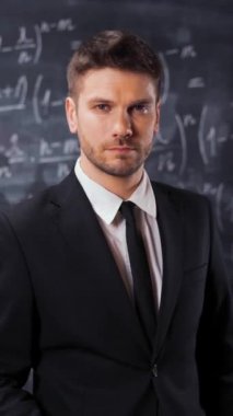 Matematiksel formülün yanında duran bilim adamının portresi, denklemler. Gözlüklerini taktı ve ciddi görünüyordu. Zeki ve zeki öğretmen konsepti. Dikey Vuruş çalışalım..