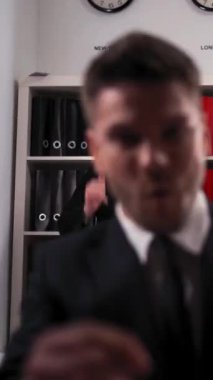 Masa bilgisayarı grafikleriyle kameranın önünde neşeli bir şekilde dans eden üç iş adamı. Cuma gününün 4k Ultra HD çözünürlüğüyle bitmesinden memnunuz. Dikey Çekim.