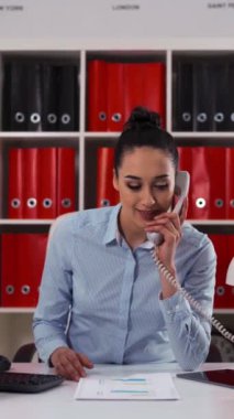 4k ultra HD genç ve çekici iş kadını bir ofiste iş arkadaşıyla konuşuyor ve mutlulukla gülümsüyor..