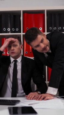 İki iş adamının büyük sorunları var ve ofiste bilgisayar başında çalışırken büyük kayıplar verdiler. Kaybedenler hayal kırıklığı konsepti. 4k UHD Dikey Çekim.