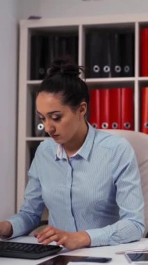 Resmi takım elbiseli ve kravatlı bir iş adamı, meslektaşı bayan çalışanına masaüstü bilgisayar bilgisayarında iyi bir iş çıkardığı için övgüde bulunuyor. Orta atış. Dikey Çekim.