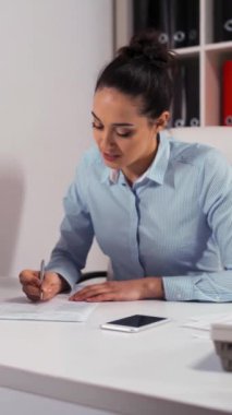 Ofisteki bir iş kadını ve müvekkil arasındaki randevu. Sözleşmeye giriyorlar. Girişimci belgeleri imzalar. Dikey Çekim.