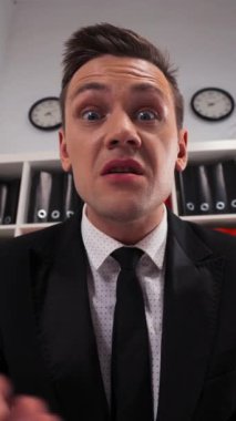 Çekici Avrupalı yakışıklı iş adamı modern ofiste senden nefret ediyor. Kamera görüntülerindeki etkileyici negatif duygu geniş açılı görüntüler. Dikey Çekim.