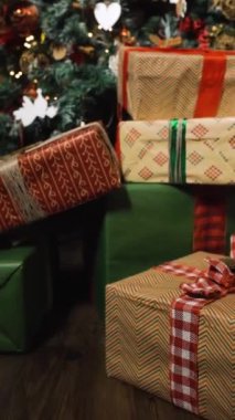 Hediyelerle süslenmiş Noel ağacının yakın çekimi. Kaydırmalı kamera hareketi. 4k uhd Dikey Vuruş.