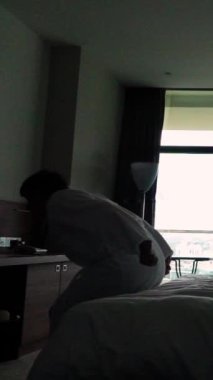 Ağır çekim. Bornozla otelde yatağa atlayan mutlu adam. Güzel daireler, rahatlama. Sıkı çalıştıktan sonra rahatlama kavramı. Tatil günü. Geniş açı 1000 fps dikey atış.