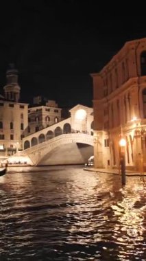 Venedik 'in gece mimarisi Merkez Kanal' dan görüntüsü. Tarihi binaların yakınında ay ışığı ve su yansımaları. Dikey çekim.