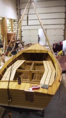 Atölye içinde yelkenli direkli ahşap tekne. Steadicam geniş açı çekiyor. Ev yapımı Sailbaot gölde ya da nehirde taşınmaya hazır. Dikey Çekim.