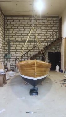 Kapalı alanda yelken direkli ahşap tekne. Geniş açı. Ev yapımı Sailbaot denize, göle ya da nehre açılmaya hazır. Büyük hobi konsepti. Dikey Çekim.