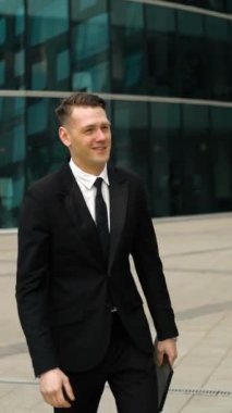 İki başarılı dostu Avrupa işadamları tablet Pc ve cep telefonu yürüyüşlere birbirlerine karşı ile tanışır ve bir gülümseme ile el sallıyor. Arka bina çarpıcı parlak İş Merkezi