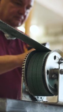 Tekne direği ve kapalı alan atölyesi 4K ile çalışan usta. Römorkun bağlayıcılarını sıkılaştırıyor. Dikey Çekim.