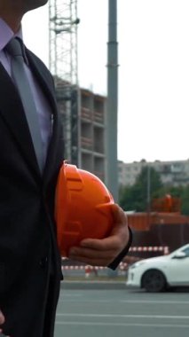 Ağır çekim. Çekici mühendis telefonda konuşuyor. Kask kolundan, gülümseyerek ve aramayı cevaplama dayadı. Onun projesi kabul edildi. Yeni bina inşaat ile vinç ve ışınlar,