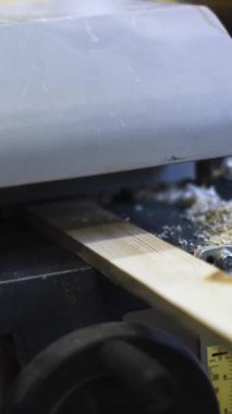 Ahşap işçiliği ustası. Ahşap bloğun içeriyi kestiği yakın plan. Talaş. Dikey Çekim.