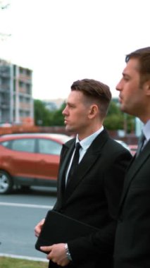 4 k. Uhd. El sıkışma. Tablet Pc ve metin pad hesaplama konusunda konuşurken yeni planı bg binasında inşa ile turuncu kask içinde üç genç iş adamları, müşteriler ve mühendis mimar