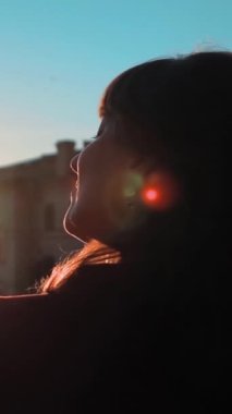 Ağır çekim. Güzel genç başarılı iş kadını etrafında dönen ve çok mutlu ve eğlenceli görünüyor gündoğumu. Steadicam günbatımı yakın çekim. Temiz mavi gökyüzü. Rüzgarla çırpınan saç. Yeşil ve turuncu tarzı