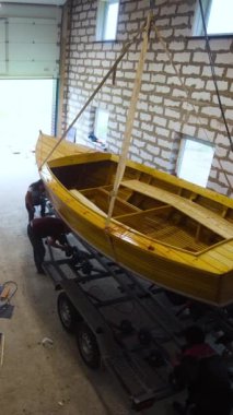 Garaj atölyesinde insan ve kamyonla ahşap tekne yapmış. İthalat için hazırlık. Sabit durağan bir atış. Dikey Çekim.