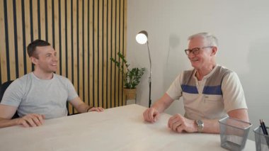 İki arkadaş canlı bir sohbetteyken ekranda bölünmüş bir şekilde konuşuyorlar. Kahkahaları ve sezgileri paylaşıyorlar, mesafeye rağmen sıcak bir bağlantıyı vurguluyorlar..